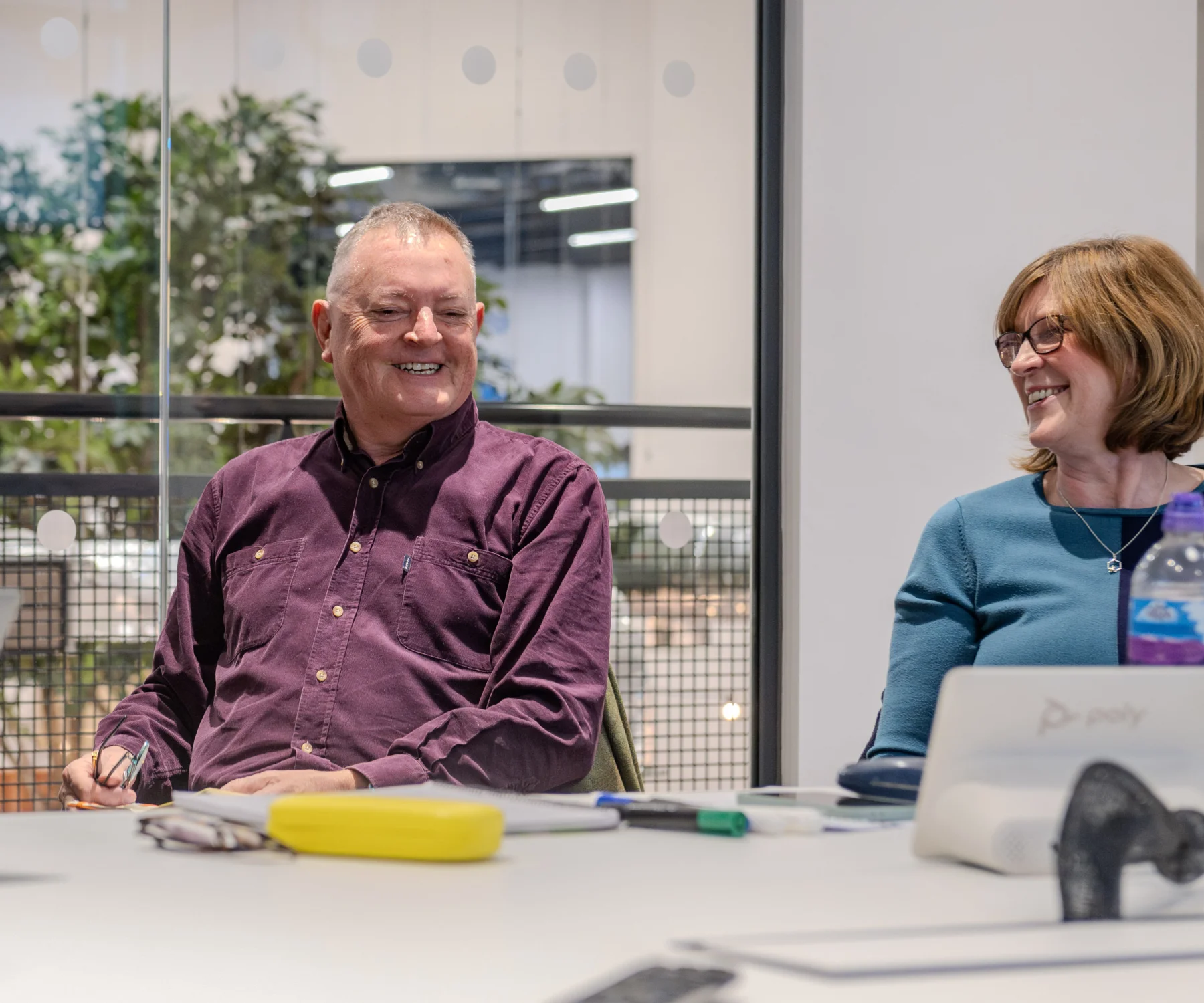 A man and woman sit at a table smiling