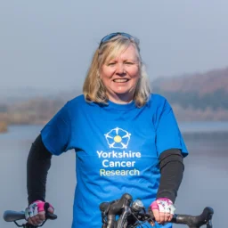 A lady wearing a blue Yorkshire Cancer Research T shirt with blonde shoulder length hair