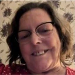 A lady with short brown hair and glasses