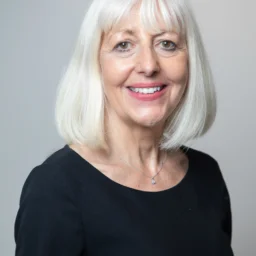 a lady with white shoulder length hair and a black top