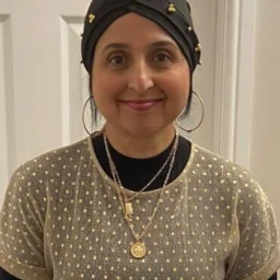 A lady wearing a hat and golden jewellery