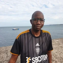 A man with glasses in a Leeds United football top