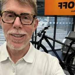 A man with a beard and glasses wearing a white shirt