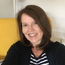 A lady with a stripy top smiles at the camera