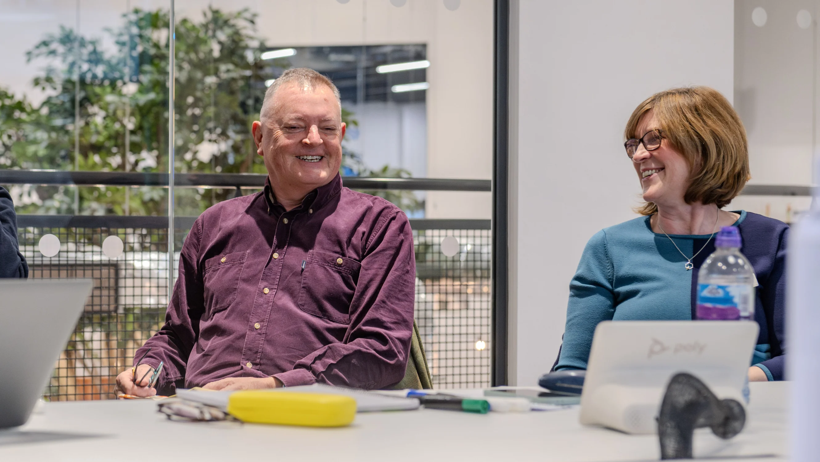 A man and woman sit at a table smiling