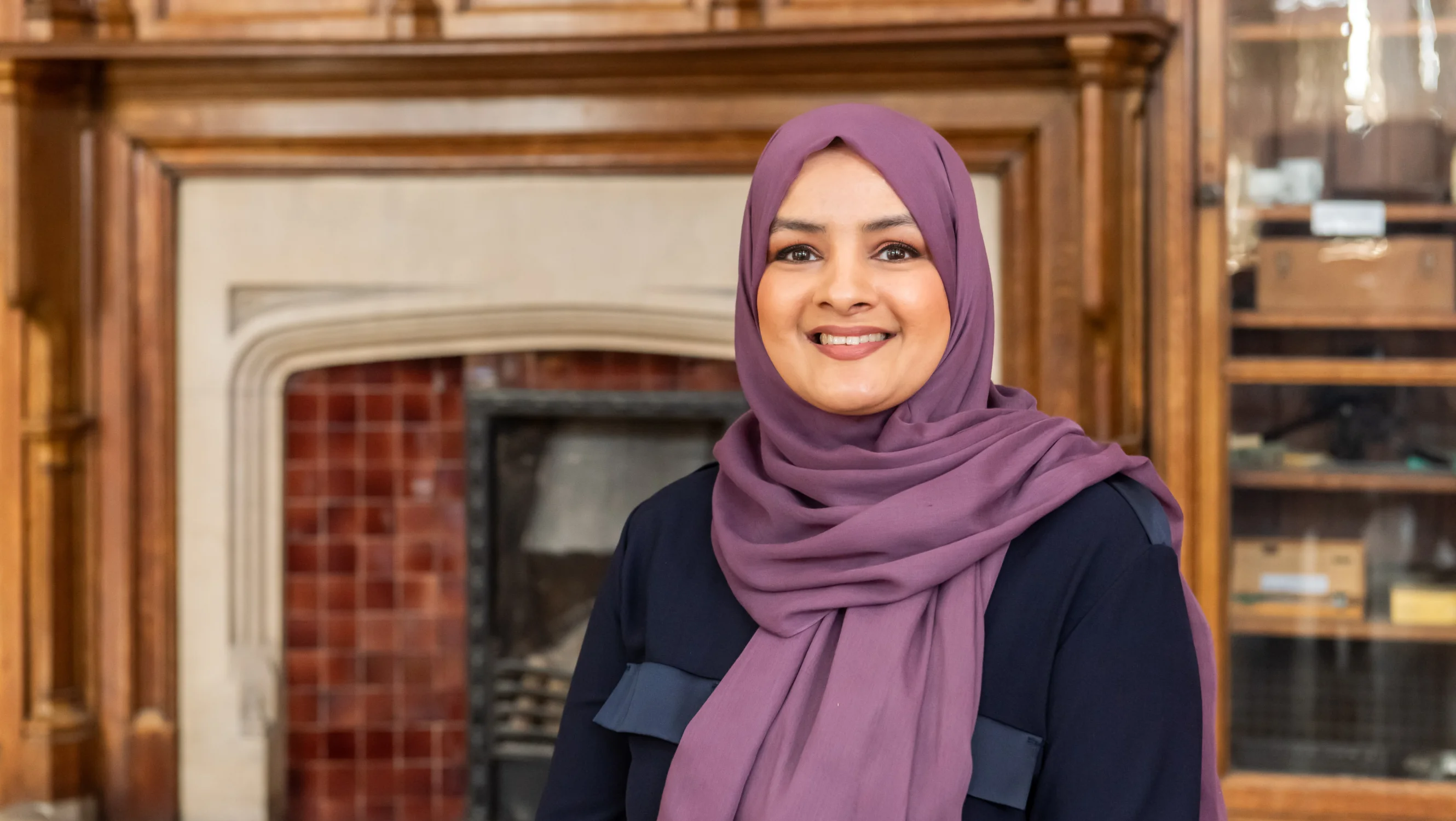 A lady in a purple hijab smiles