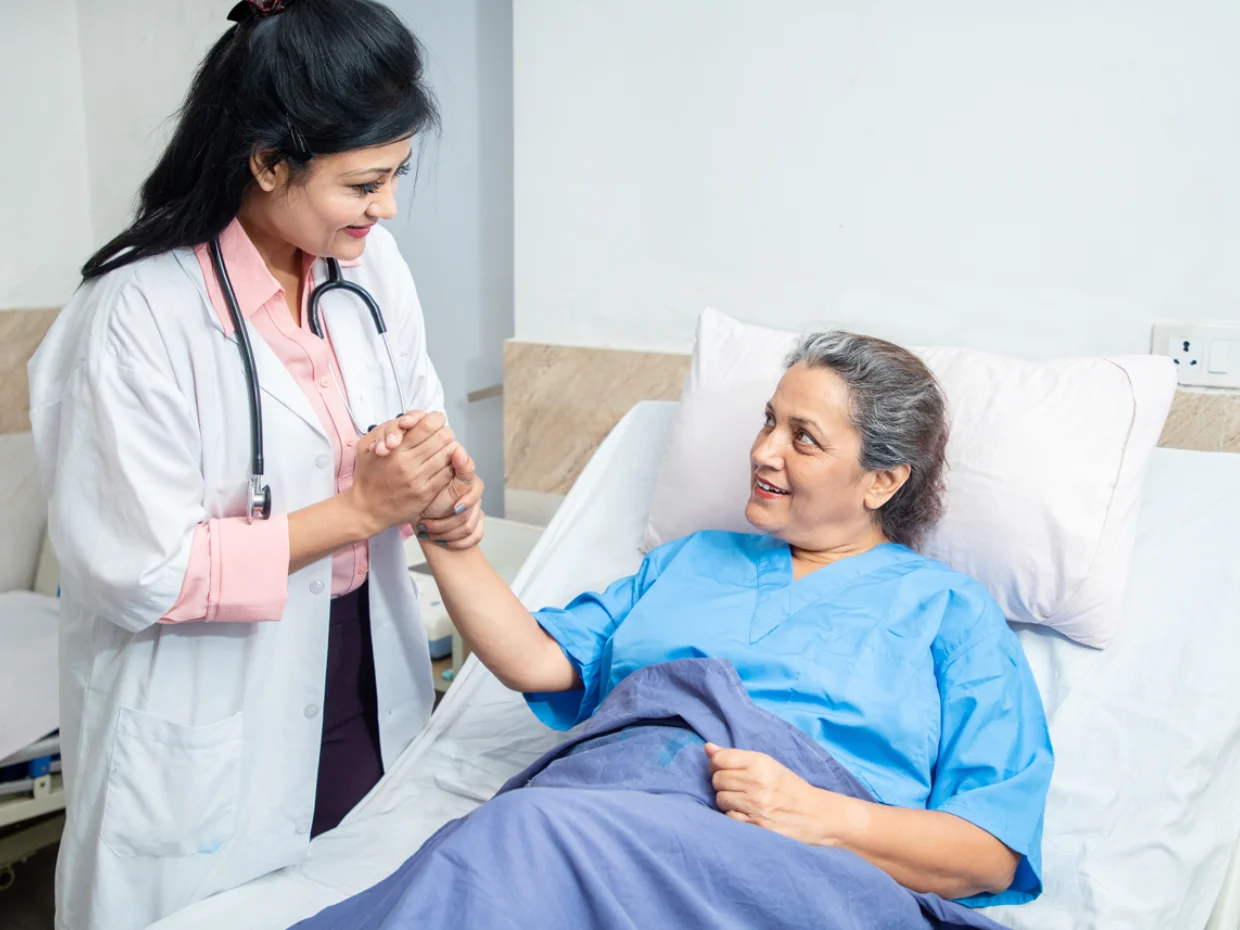 Doctor holding the hand of a patient in bed