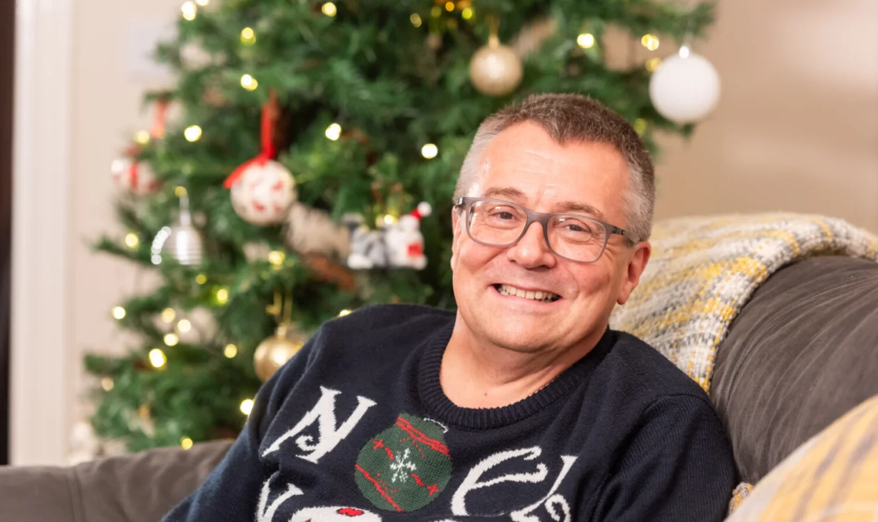 David from Leeds, smiling at the camera wearing a christmas jumper