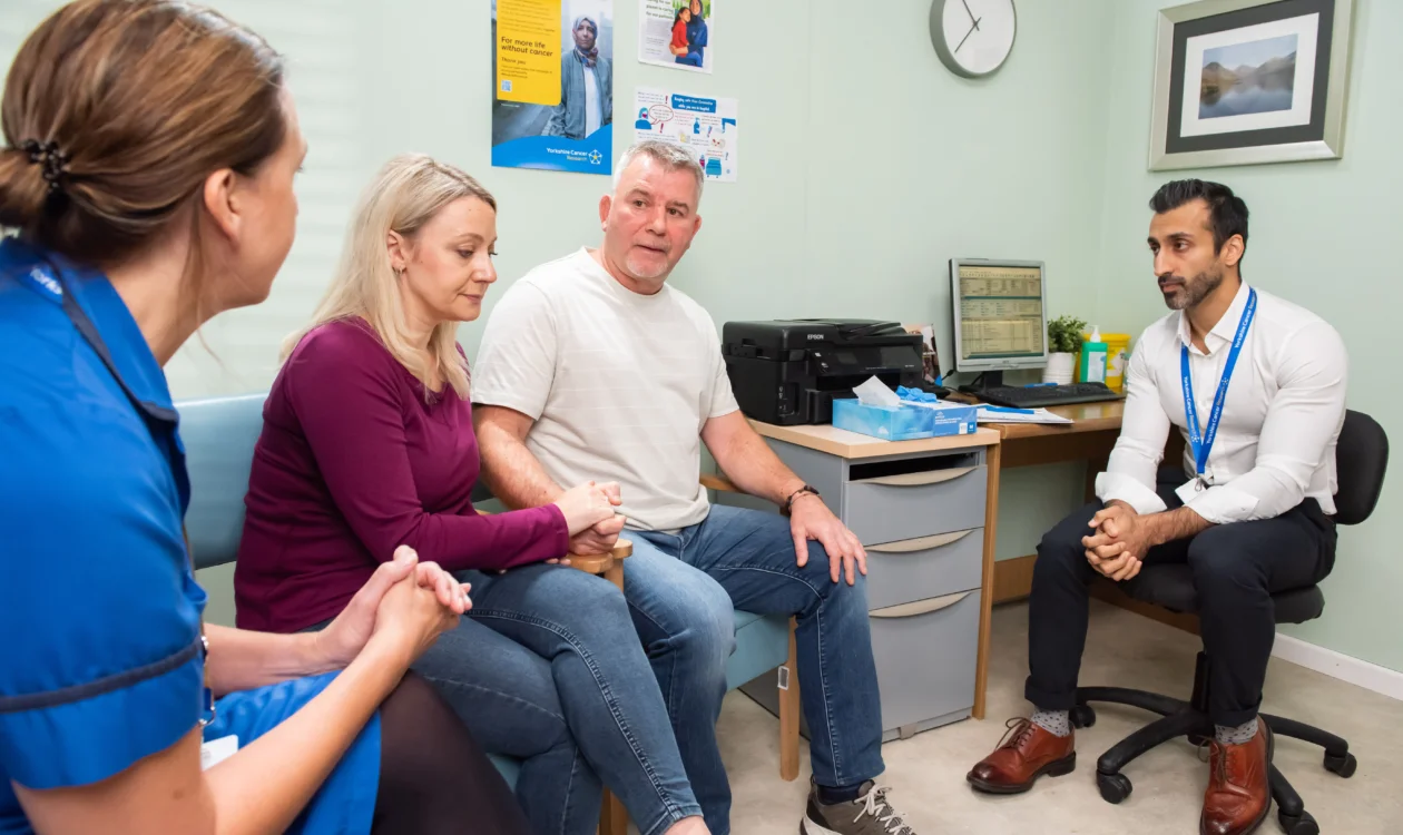 A man and his wife speak to a nurse and doctor
