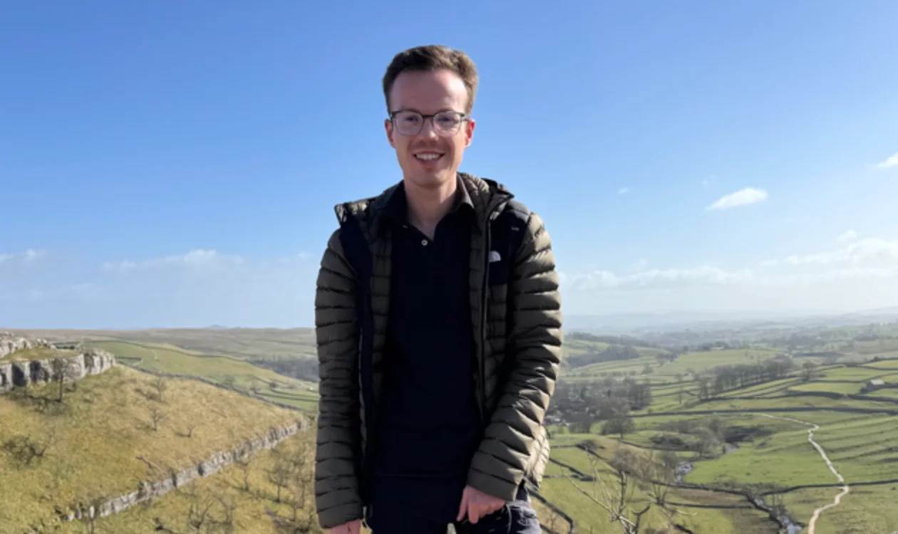 Man on a hill in front of sky and countryside