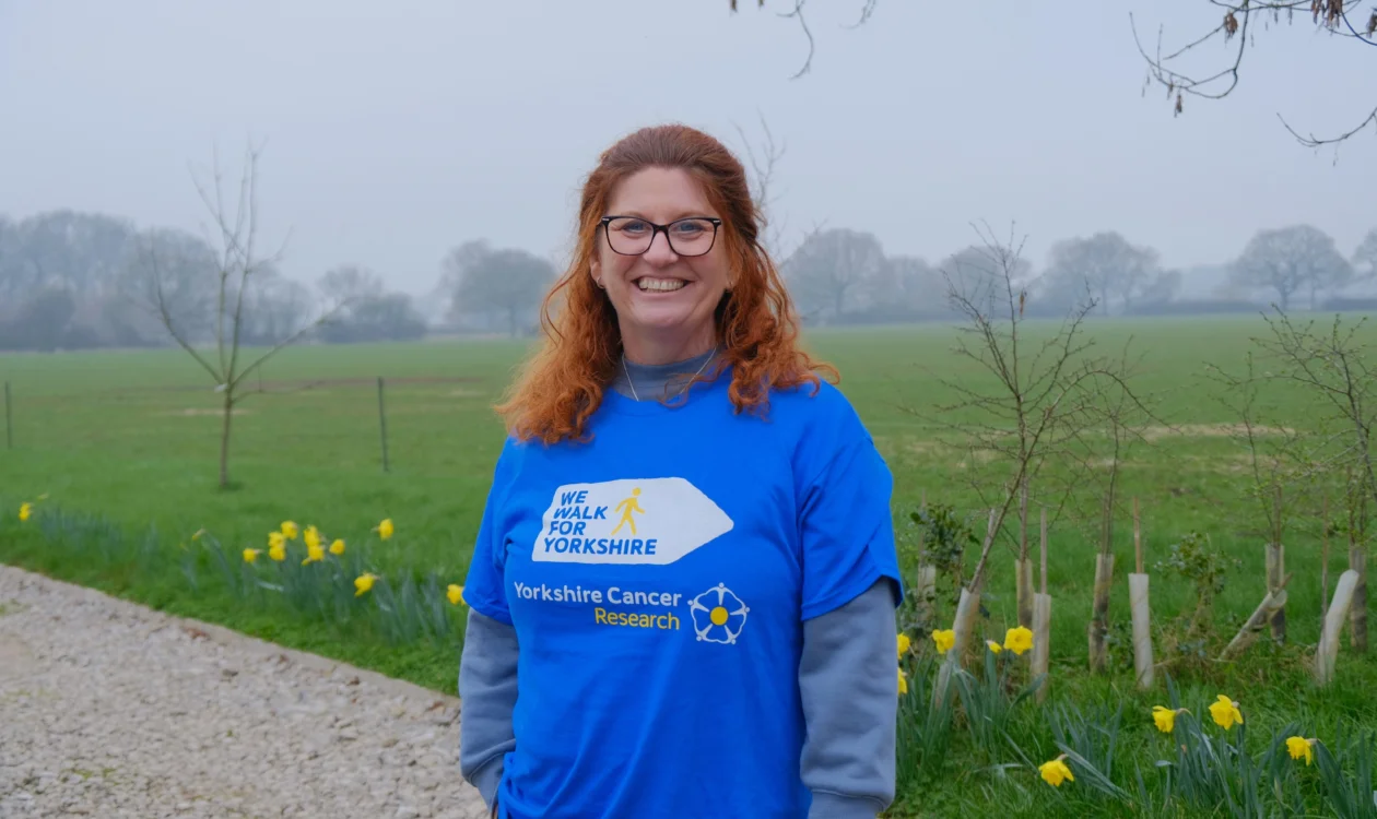 Jackie standing in front of a field with daffodils