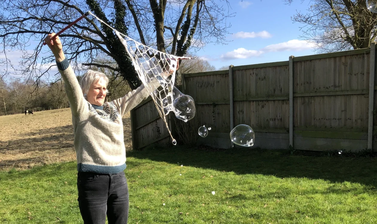 Polly raising her arms in the air with bubbles