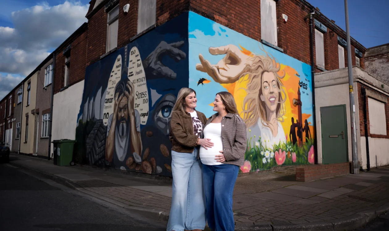 Wendy and Amy standing in front of the Turn the Corner campaign wall