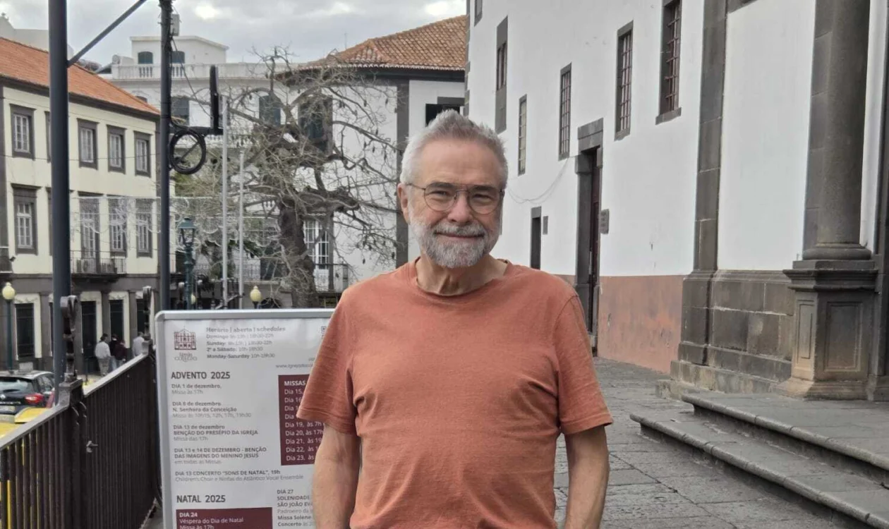 Man in orange t shirt standing in street