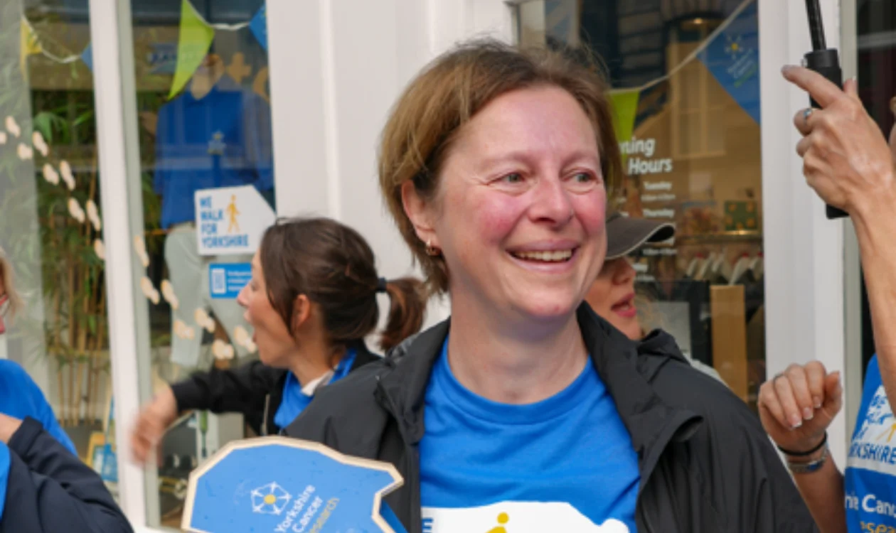 Lisa holding the Baton for Yorkshire in front of the Harrogate shop