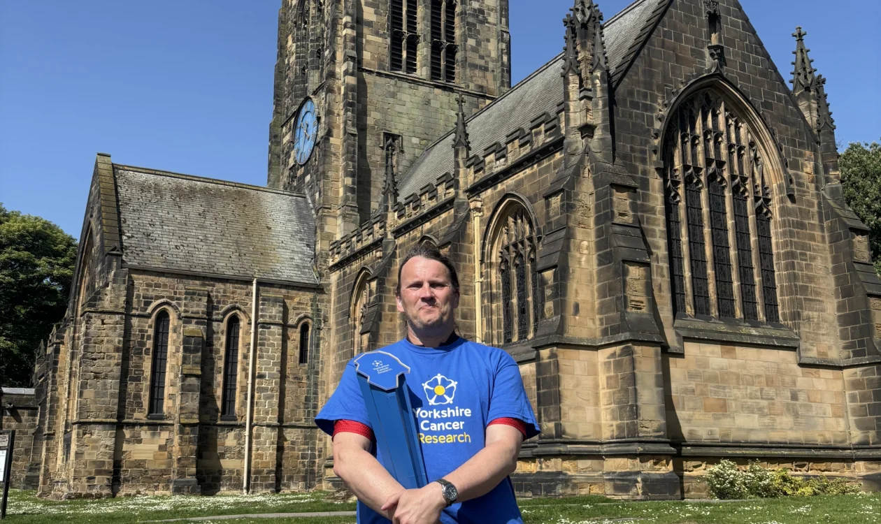 Phil holding the baton in front of a church
