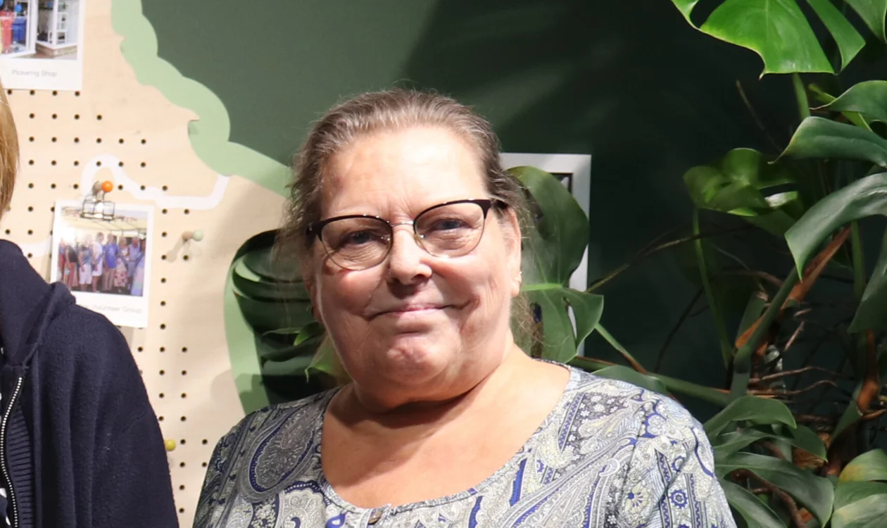Tracy Lister standing in front of a green background
