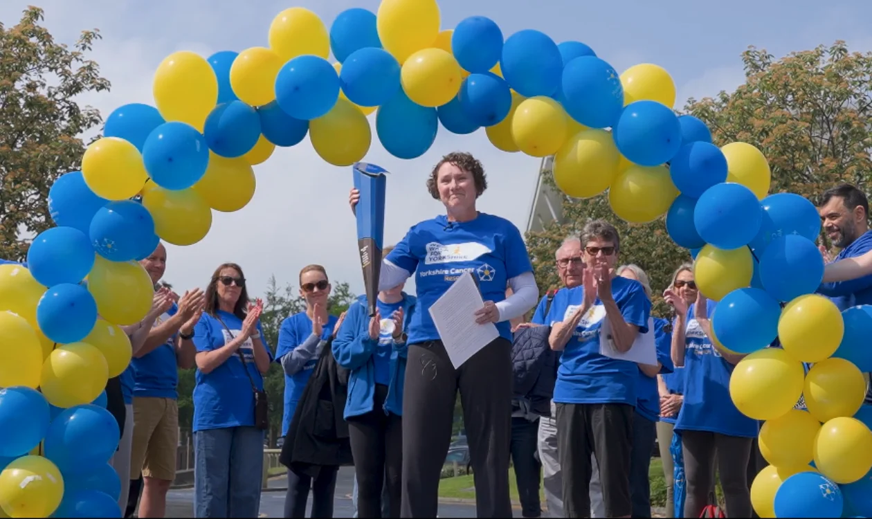 Katie holding the baton at the finish line