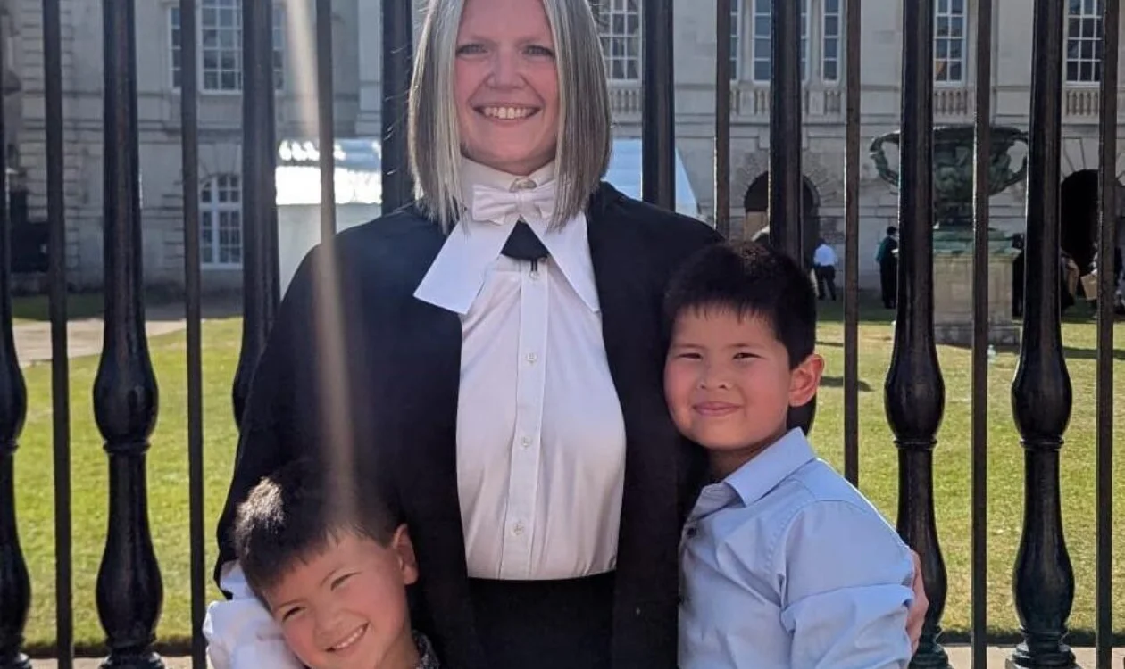 Dr Steph Archer standing in front of railing with her two children