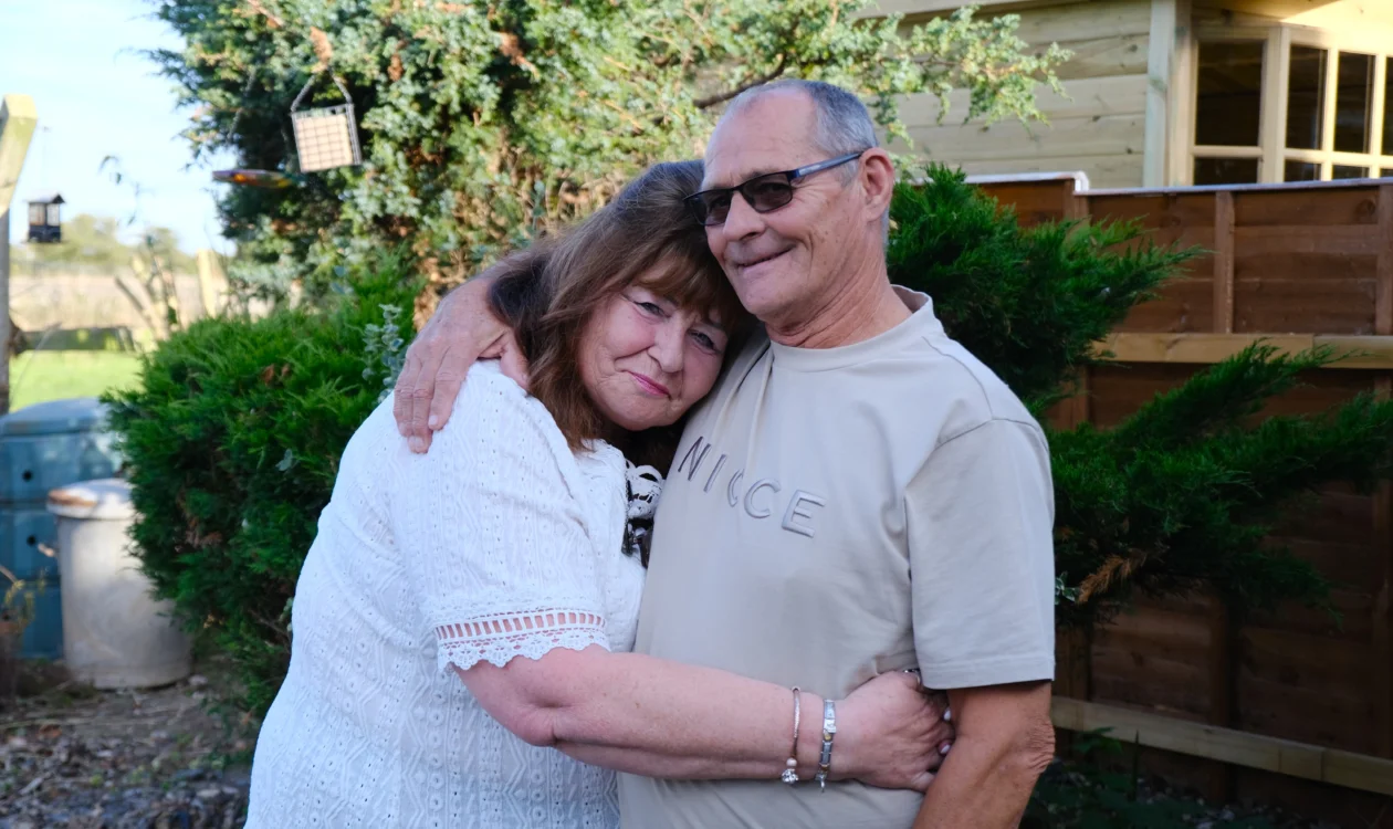 Linda and Terry hugging each other in the garden