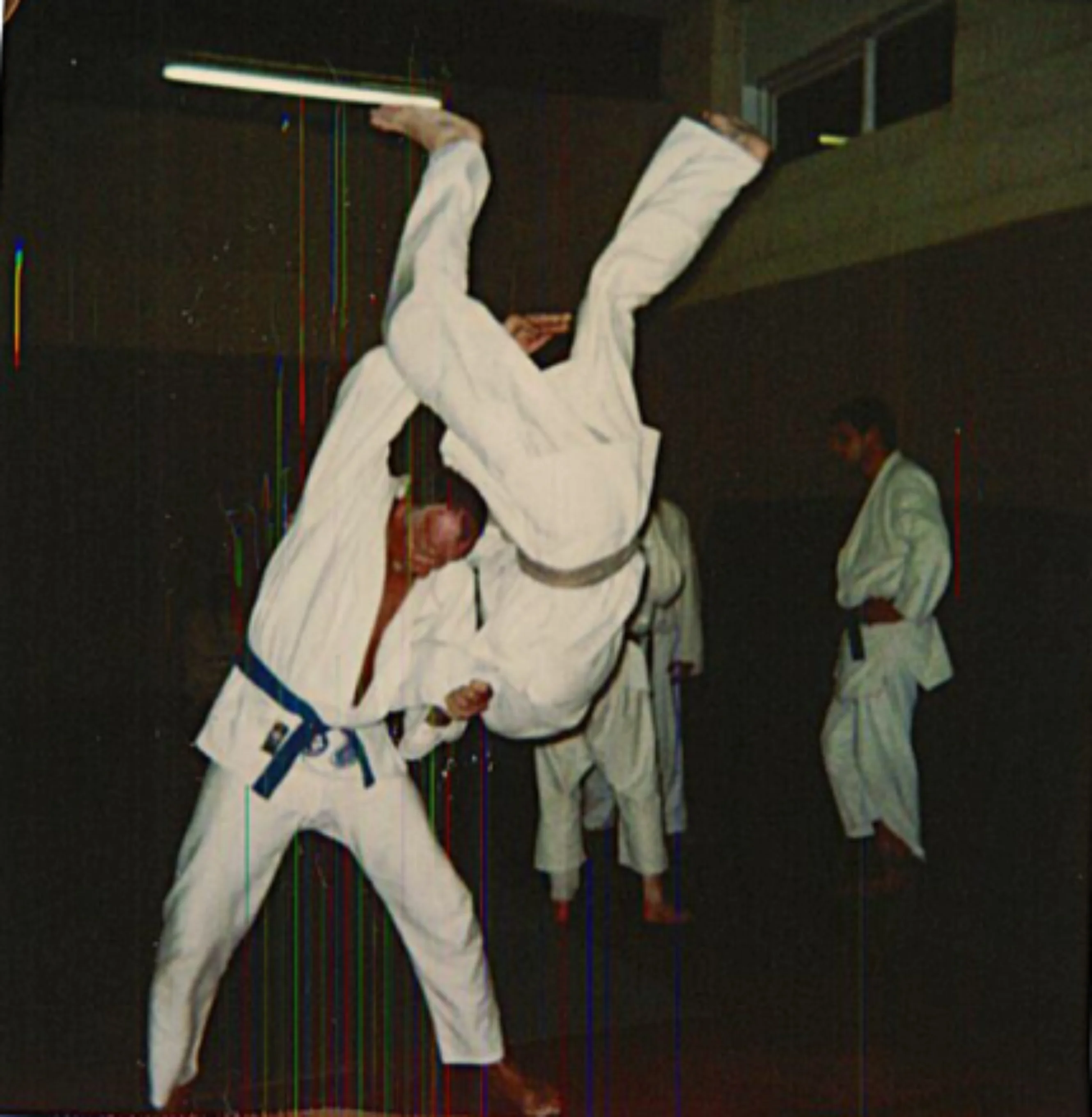 Pete Skinner throwing a competitor over his shoulder while practising judo