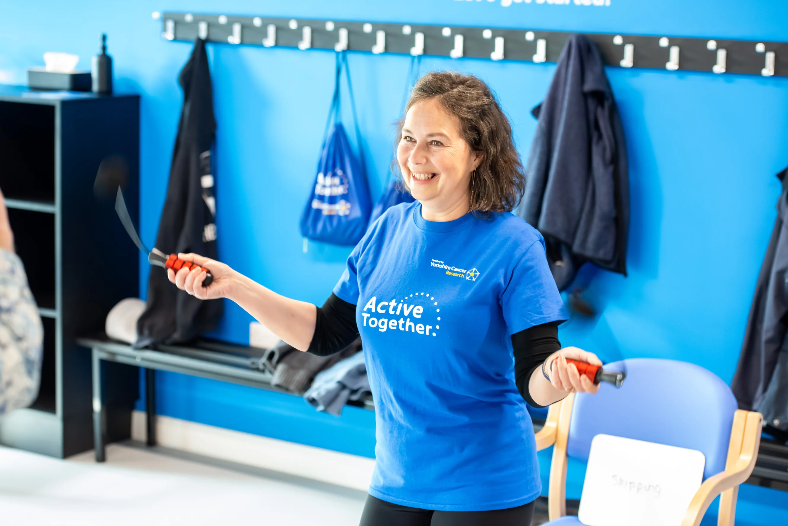 A woman in a blue Active Together t-shirt jumping rope.