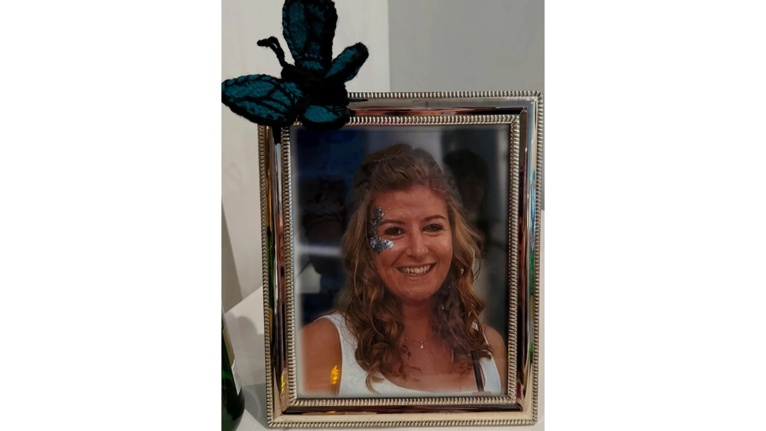 A framed photo of Kristina with a knitted butterfly on the edge of the frame.