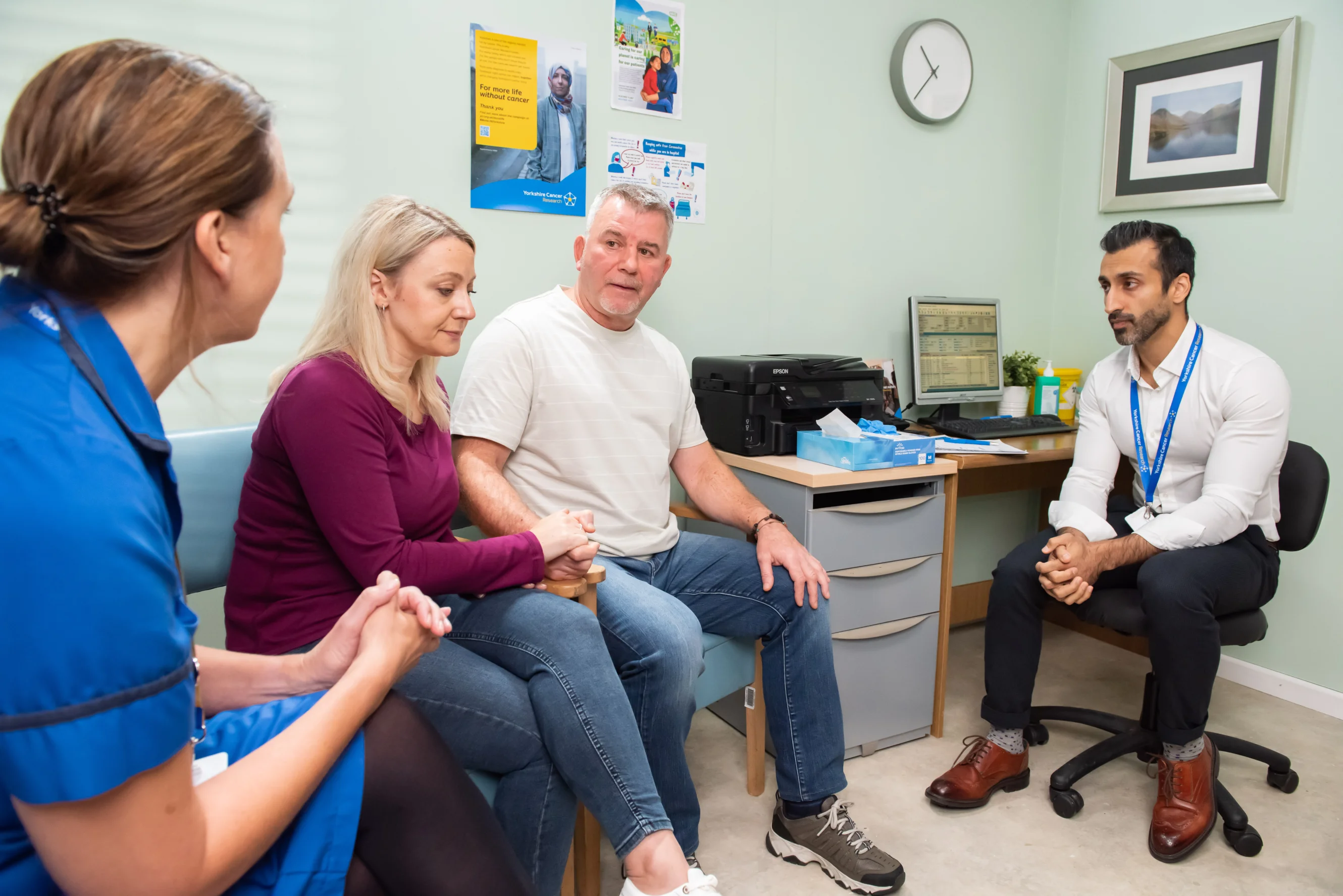 A man and his wife speak to a nurse and doctor