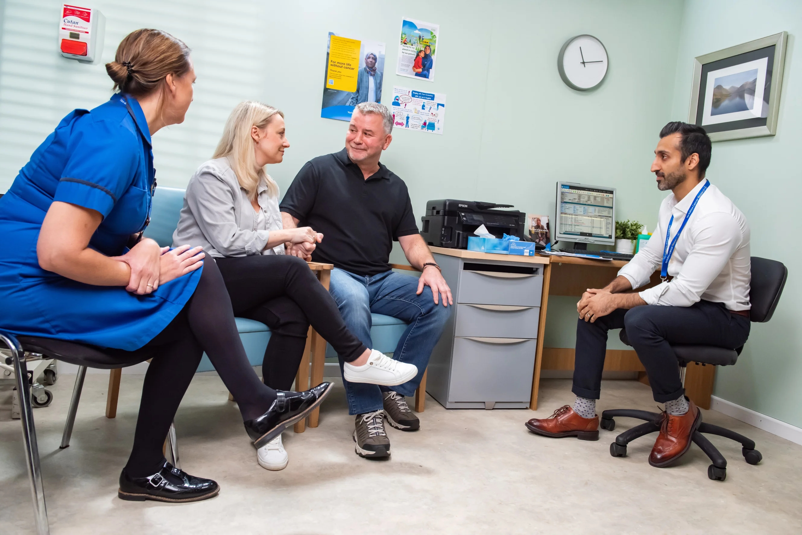 A couple speak to a doctor and nurse during a medical appointment