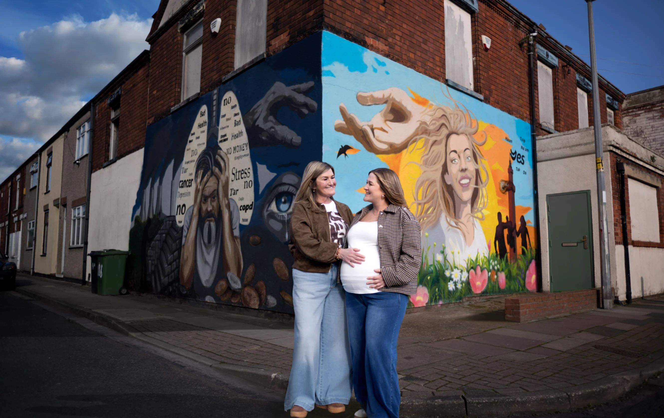 Wendy and Amy standing in front of the Turn the Corner campaign wall
