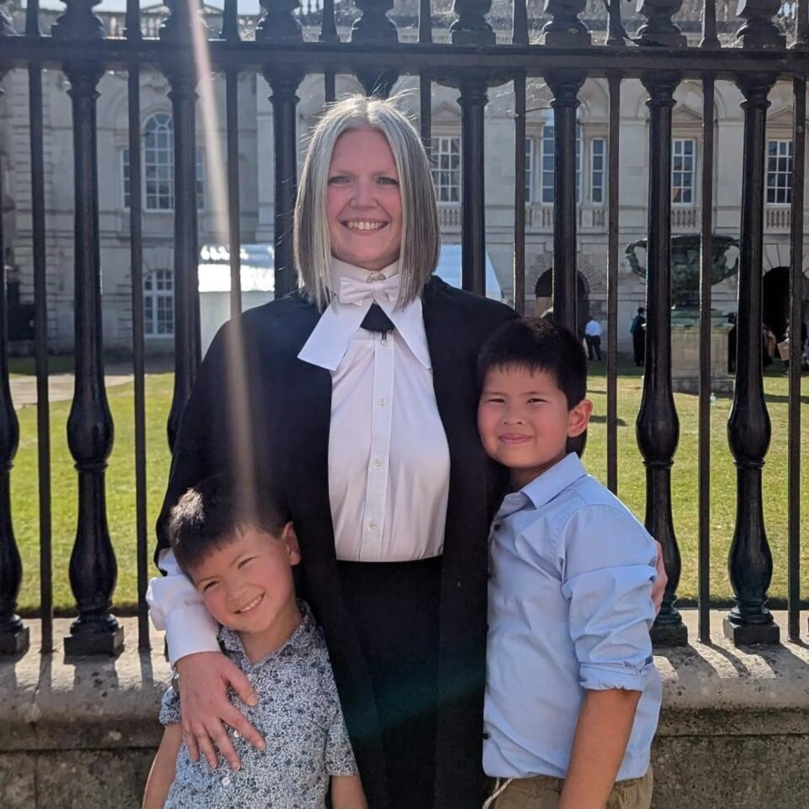 Dr Steph Archer standing in front of railing with her two children