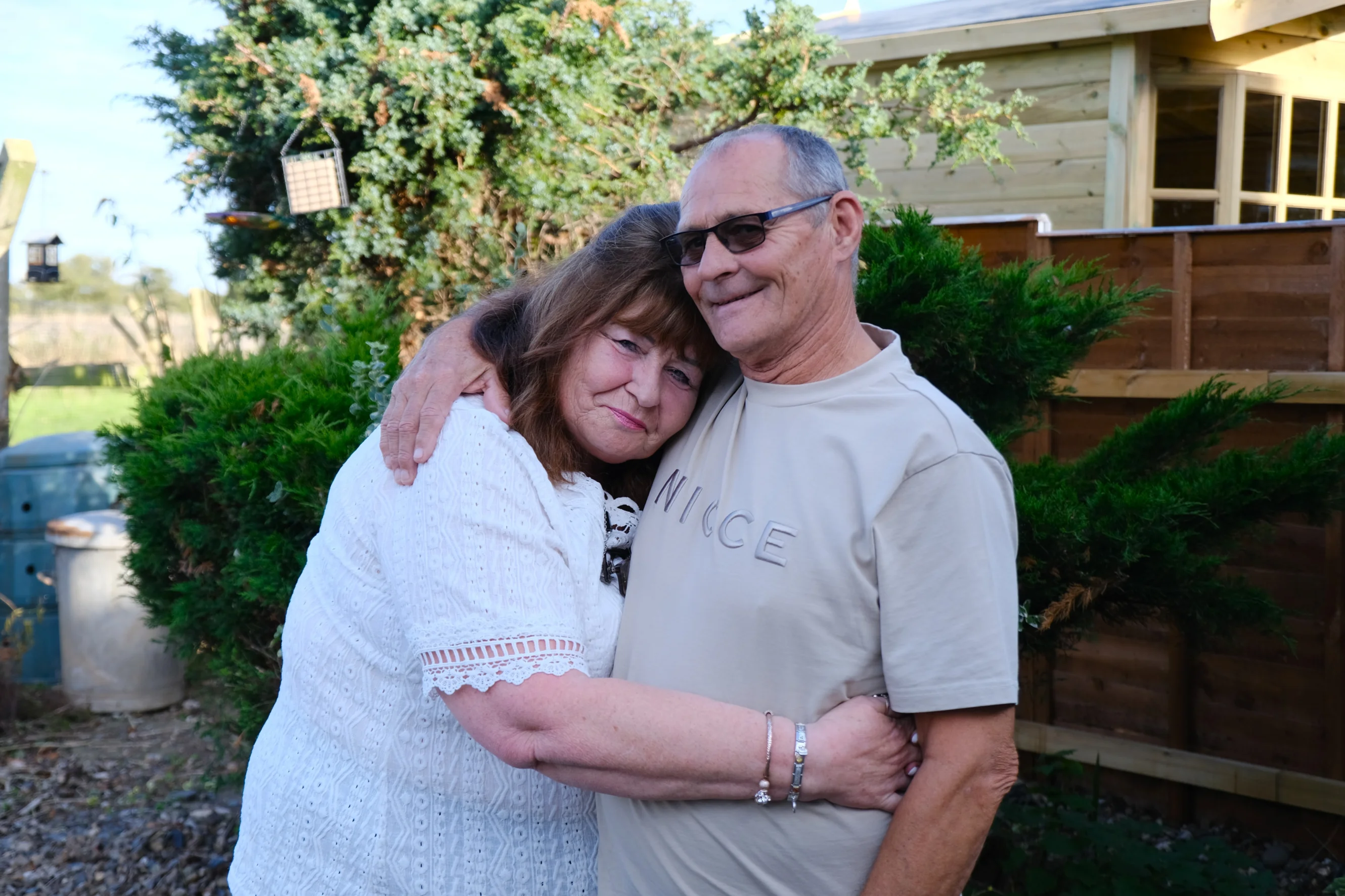 Linda and Terry hugging each other in the garden