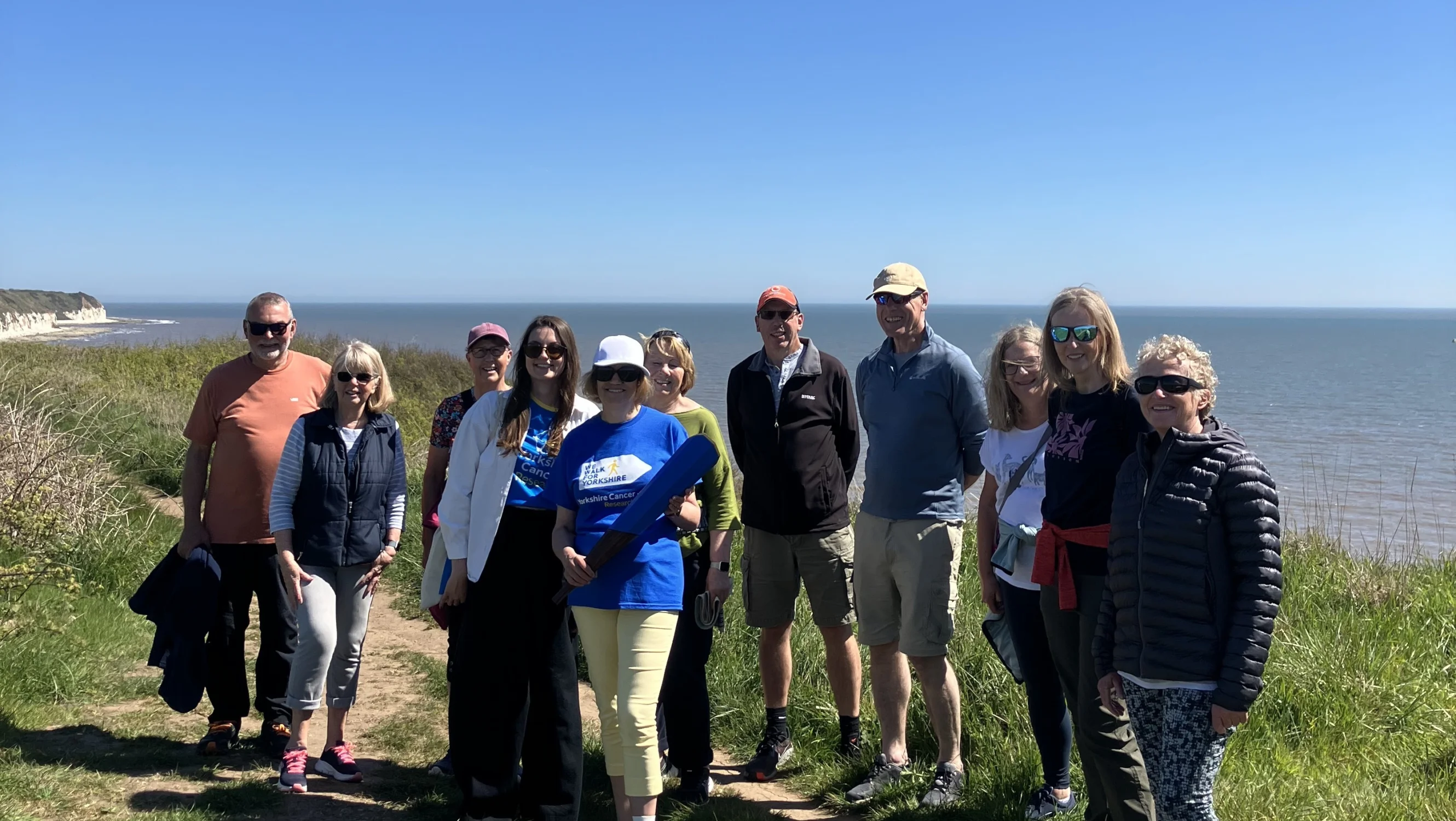 Josie and her parkrun friends standing in front of the coast