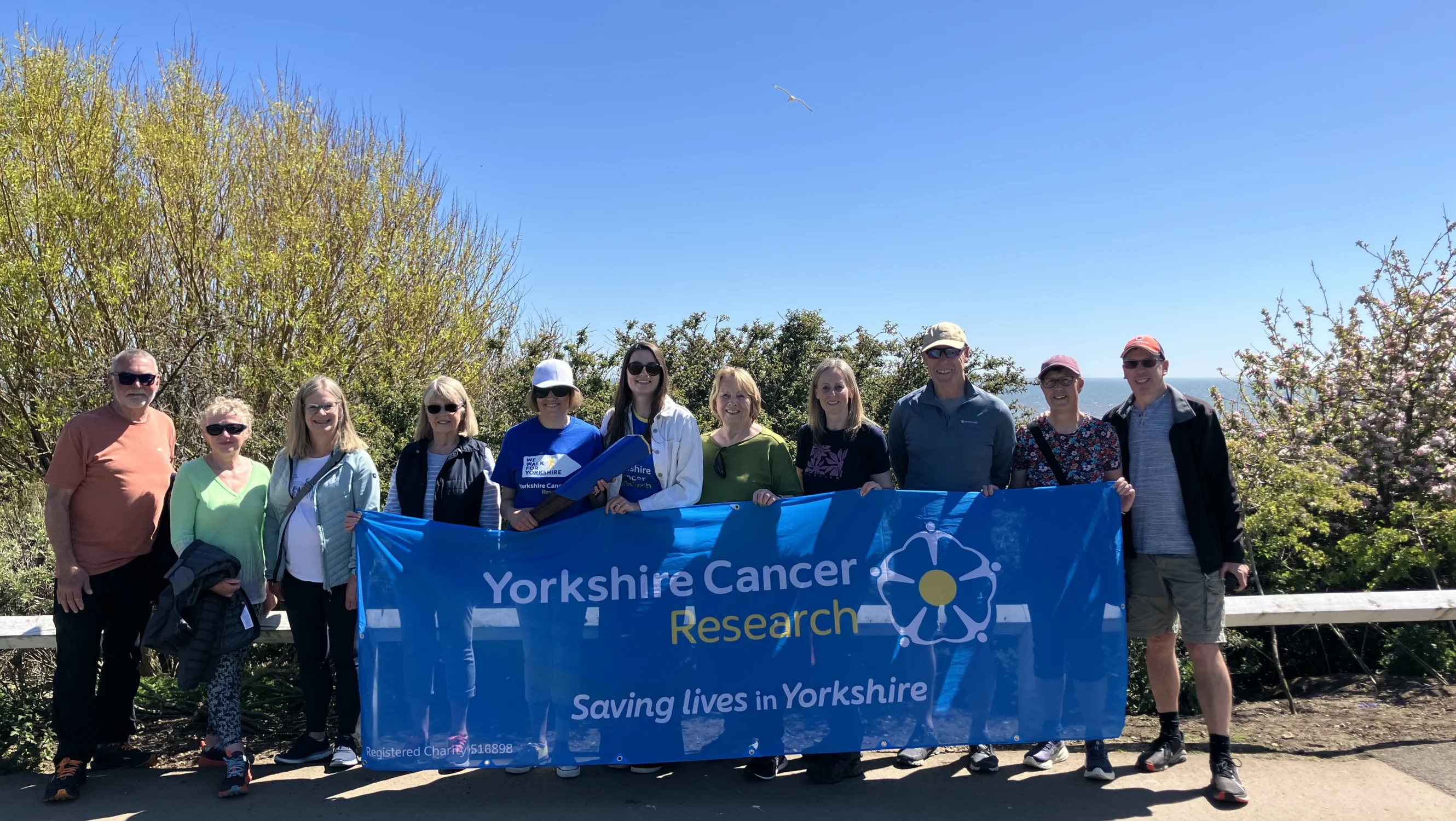 Josie and her parkrun friends holding the Yorkshire Cancer Research banner