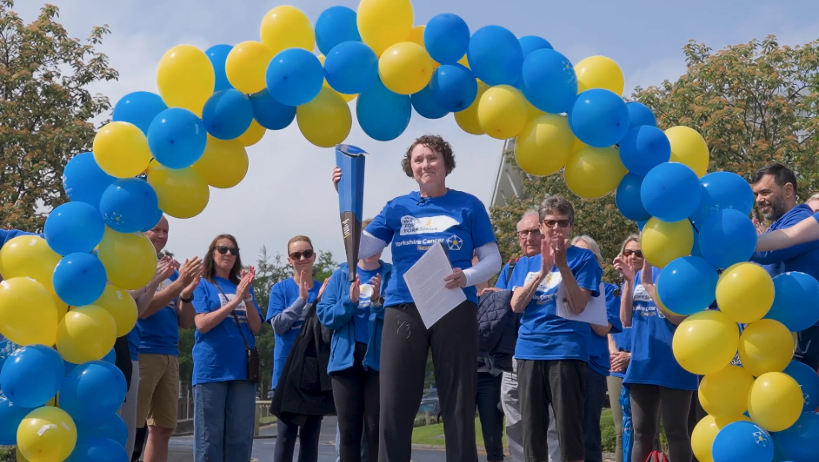 Katie holding the baton at the finish line
