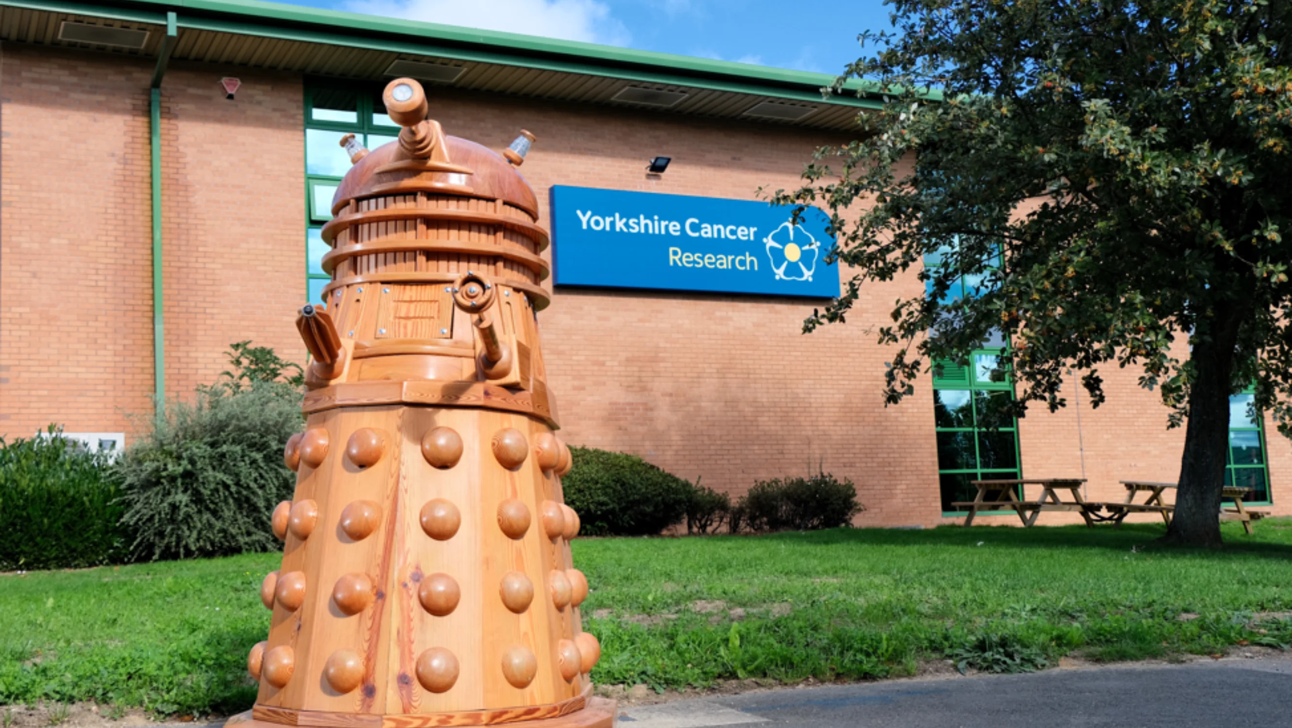 The Dalek in front of the Yorkshire Cancer Research website