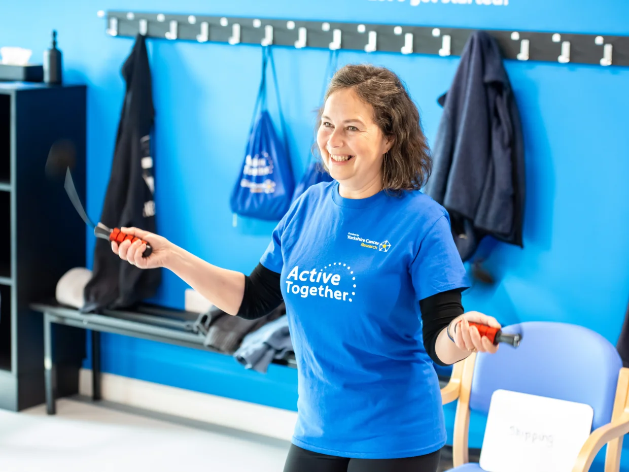 A woman in a blue Active Together t-shirt jumping rope.