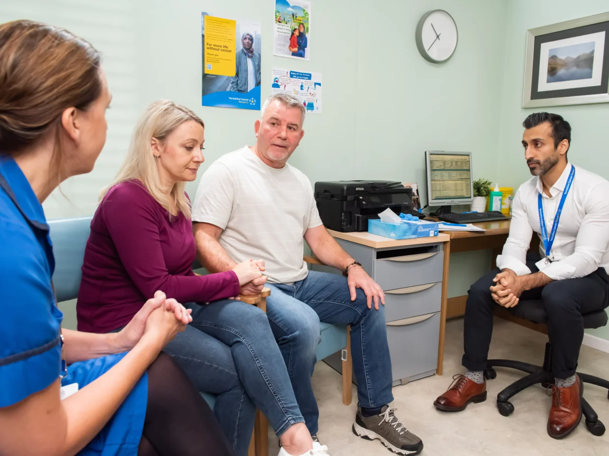 A man and his wife speak to a nurse and doctor